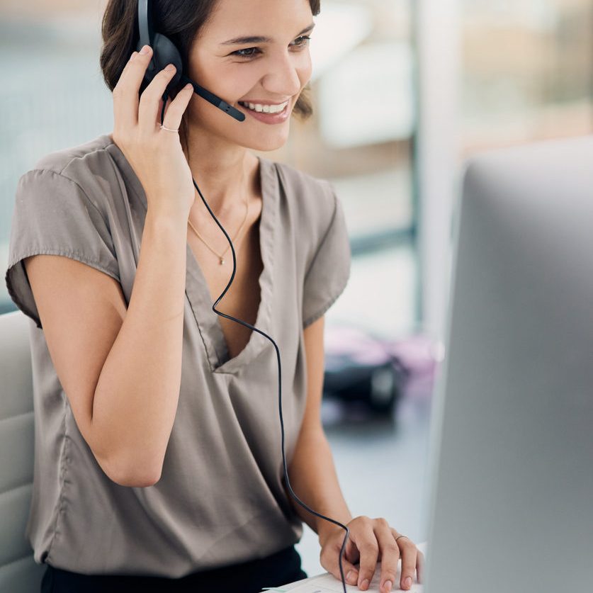 Cropped shot of an attractive young woman using a headset while sitting at her desk in the office